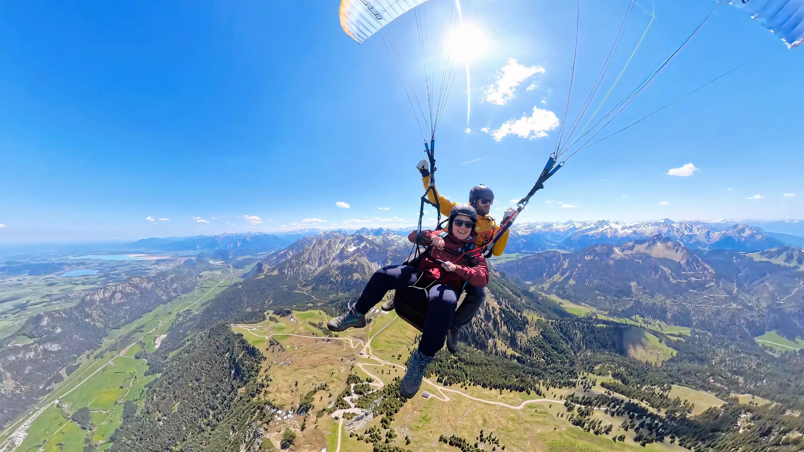 Tandem-Gleitschirmflug über Alpen bei Sonnenschein